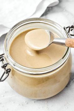 a spoon in a jar filled with peanut butter