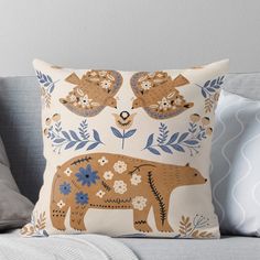 an elephant with flowers and leaves on it's back sits on a couch next to pillows