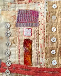 a close up of a patchwork quilt with buttons on the front and back of it