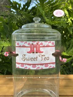 a glass jar filled with pink and brown tea sitting on top of a wooden table