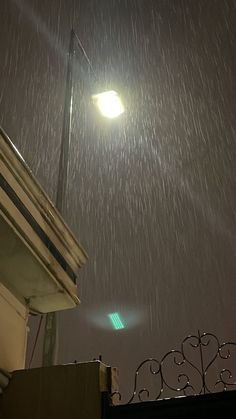 a street light is lit up in the rain