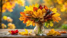 an arrangement of autumn leaves in a vase on a table with fall foliage around it