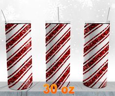 three tall red and white christmas candles with snowflakes on the top, in front of a snowy background