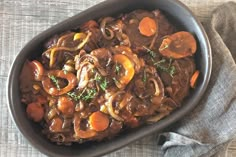 a bowl filled with meat and vegetables on top of a table