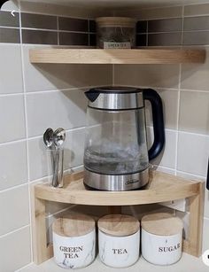 a coffee pot is sitting on a shelf next to tea cups and an electric kettle