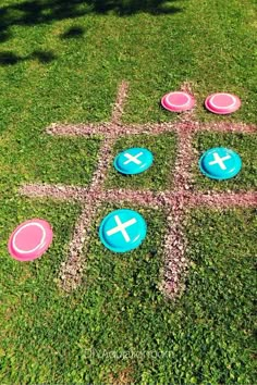 four frisbees laid out in the grass with crosses painted on them