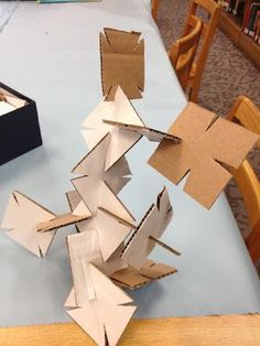 an open box sitting on top of a table next to some cardboard boxes that have been cut into shapes