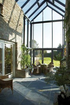 an enclosed patio area with wicker furniture and large glass windows on the side wall