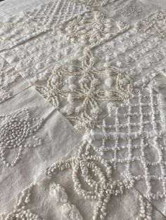 an embroidered tablecloth with white threadwork on it