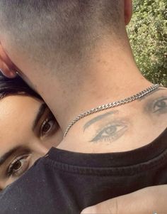 a man and woman with tattoos on their neck