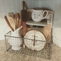 kitchen utensils and wooden spoons sit in a wire basket on the counter