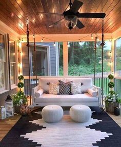 an outdoor porch with white furniture and lights on the ceiling is decorated in black and white