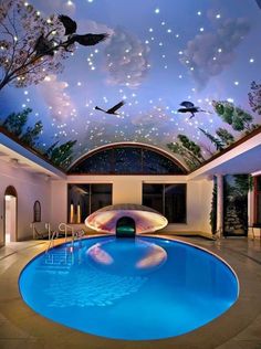 an indoor swimming pool with birds in the sky above it and a painting on the ceiling