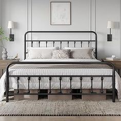 a bedroom with a metal bed frame and white linens on the floor, along with two nightstands