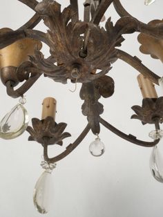 an antique chandelier with glass drops hanging from it's arms and leaves