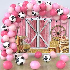 a bunch of balloons that are in front of a barn door with a cow theme