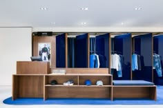 a blue and white room with clothes on display