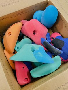 a box filled with lots of different colored plastic toys in it's cardboard packaging