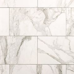 white marble tiles with grey veining on the edges and bottom, as well as an abstract design