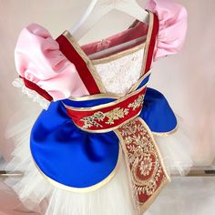 a dress made to look like a ballerina's outfit with pink, blue and gold trim