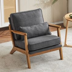 a gray chair sitting on top of a white rug next to a table with a plant