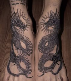 two feet with dragon tattoos on them