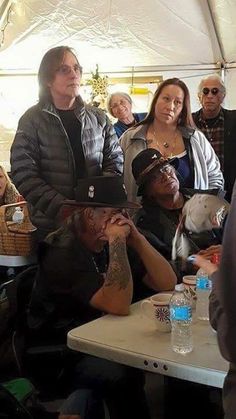 a group of people sitting at tables in a tent