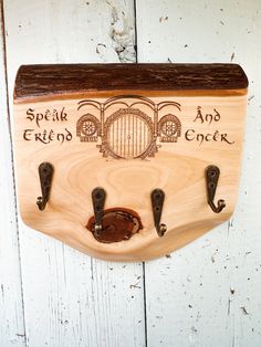 a wooden plaque with hooks on it that says speak, friends and crocker