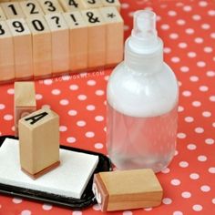 a bottle of lotion sitting on top of a table next to blocks and a phone