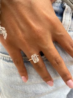 a close up of a person's hand with a diamond ring on their finger