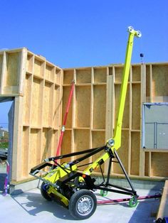 a construction vehicle is parked in front of a building with its crane attached to it