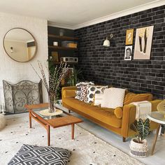 a living room with black brick walls and yellow couches, white rugs and coffee table