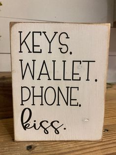 a wooden sign that says keys wallet phone piss