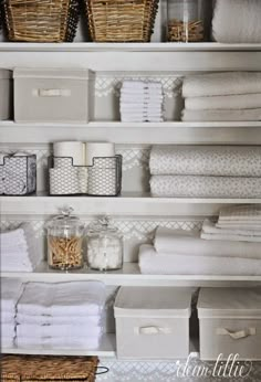 the shelves are organized with baskets and towels