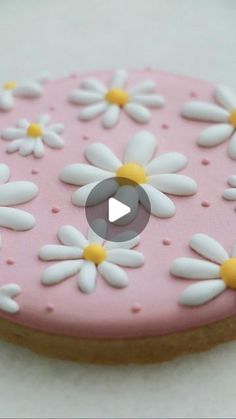 a decorated cookie with white and yellow flowers on it