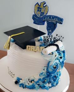 a graduation cake decorated with blue and white flowers