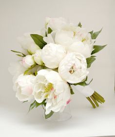 a bouquet of white flowers in a clear vase