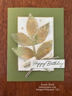 a card with some leaves on it and the words happy birthday written in white ink