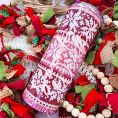 a red and white can with the word merry written on it surrounded by christmas decorations