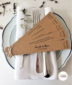 the place setting is set with silverware, napkins and tags on paper towels