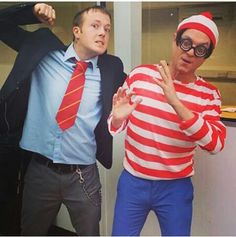 two men dressed in costumes standing next to each other with one man wearing a red and white striped shirt