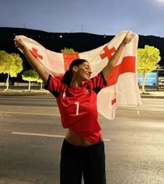 a woman is holding up a flag in the street