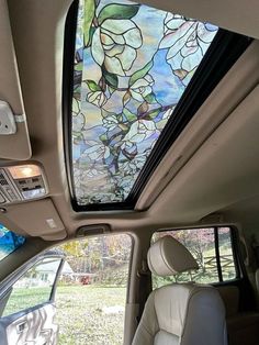 the interior of a vehicle with a stained glass skylight in the front window and passenger seat