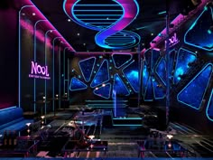 the interior of a nightclub with neon lights and artwork on the walls, as well as decorations