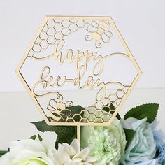 a happy birthday cake topper with flowers and greenery