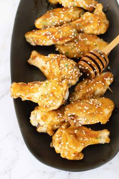 chicken wings with sesame seeds and honey on a black plate