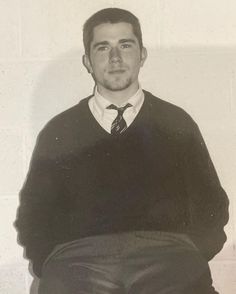 black and white photograph of a man wearing a sweater and tie