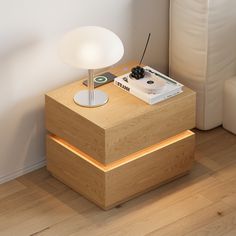 a table with a record player on it next to a white couch and lamp in the corner