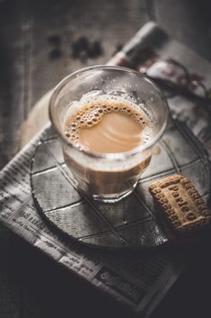 a cup of coffee and some crackers on a table