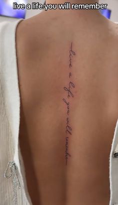 the back of a woman's neck with a tattoo that reads, live a life you will remember